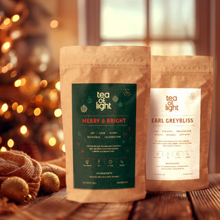 Two tea packages from Tea of Light with Christmas decorations in the background