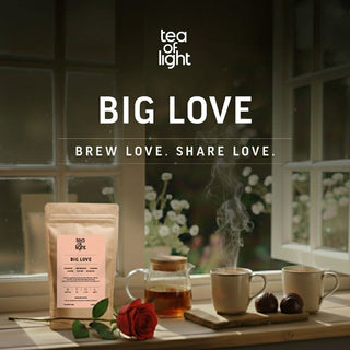 Tea of Light's Big Love tea with steaming mugs of organic tea and a rose. 