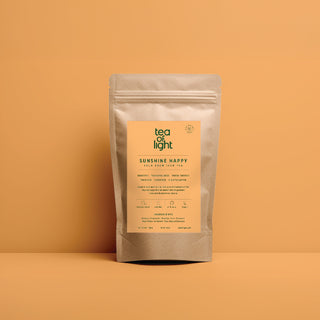 Tea of Light's Sunshine Happy Cold Brew Iced Tea packaging on oranage background